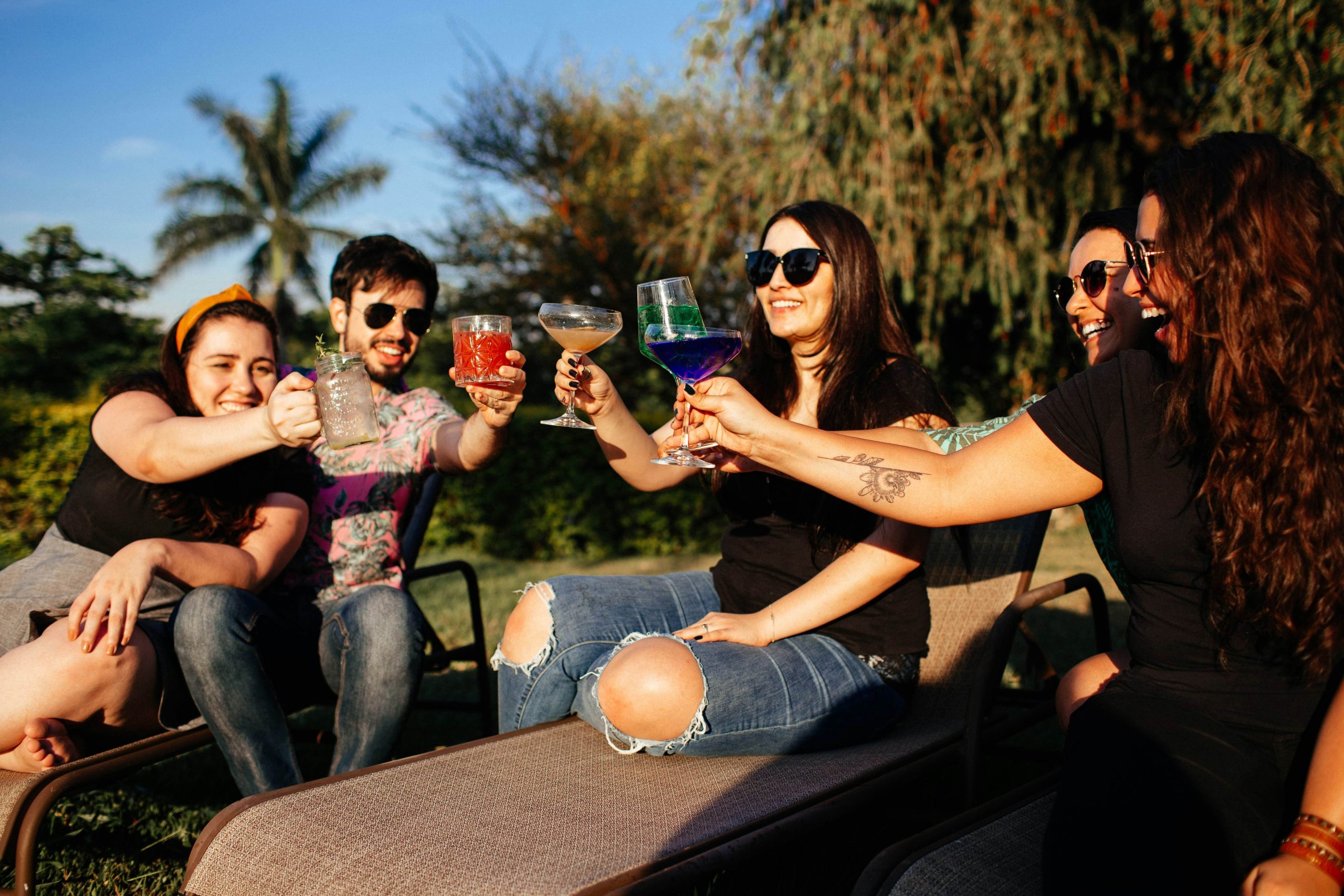 Four friends cheers drinks and smiling when they are at functions